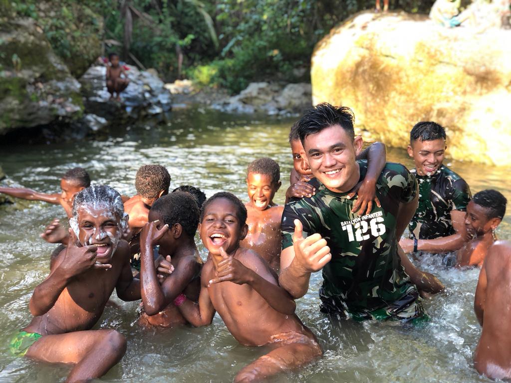 Riang Gembira, Satgas Yonif 126/KC Ajak Anak-anak Papua Bermain Di Sungai